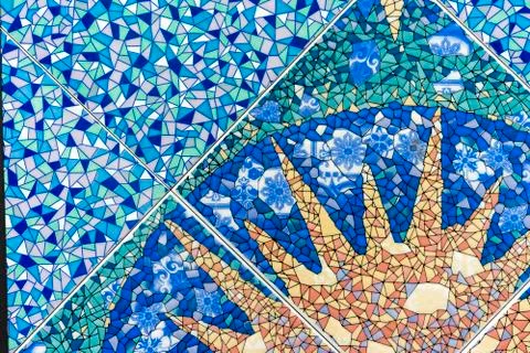 Blue ceramic mosaic tile with the image of the sun. Background of ceramic tiles. Stock Photos