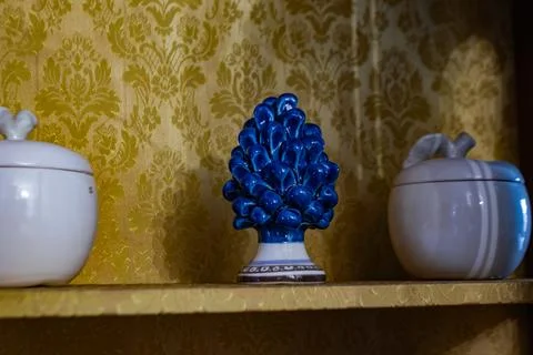 Blue ceramic pine between two white containers on a golden pa.. Foto stock