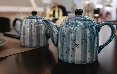 Blue ceramic teapot on the table in restaurant. Ceramic teapot of blue color Stock Photos