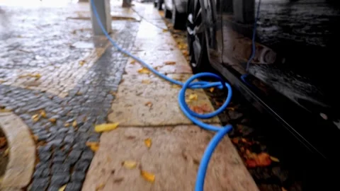 Blue Charging Cable on Cobblestone Sidewalk Stock-Footage 338041599