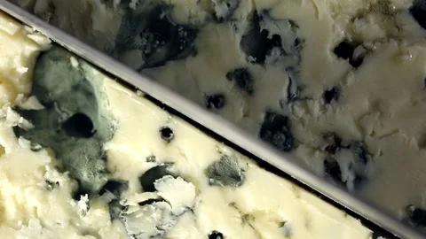 Blue cheese is cut with a knife macro view Video stock 104972858