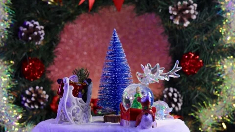 A blue Christmas tree surrounded by Santa Claus, a deer and a glass ball Stock Footage 283526424