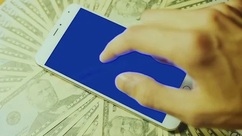 Blue chroma key touch screen of smartphone on pile of dollar bills Stock Footage 72322937
