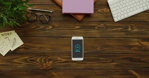 Blue circle of percents on grey screen updating the white smartphone which lying Stock Footage 95097012