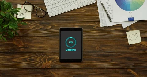 Blue circle of percents on grey screen updating the black tablet computer which Stock Footage 95098178