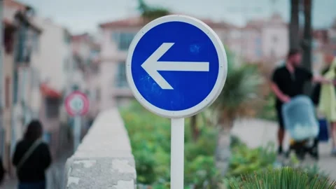 Blue circular traffic sign with white arrow pointing left on street in Euro.. Stock Footage 339118302