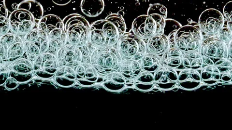Blue Clear Bubbles Form and Float to Another Ones on Transparent Surface on Stock Footage 262028676