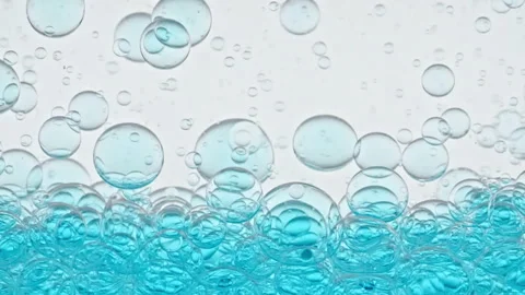 Blue Clear Bubbles Form and Float to Another Ones on Transparent Surface on Blue Stock Footage 272590910