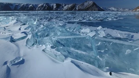 Blue clear iceberg ice large hummocks crack Baikal Lake Russia Mountains Aerial  Stock Footage 87720119