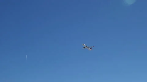 In the blue clear sky, a plane taking off is gaining altitude Stock Footage 151086826