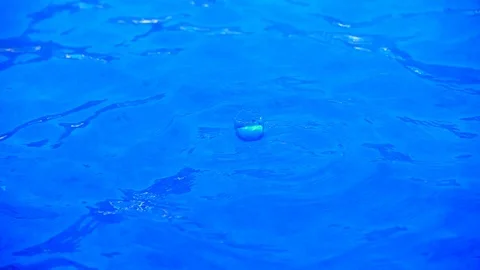 Blue clear water with small waves and splashes from dripping drops Stock Footage 92210724