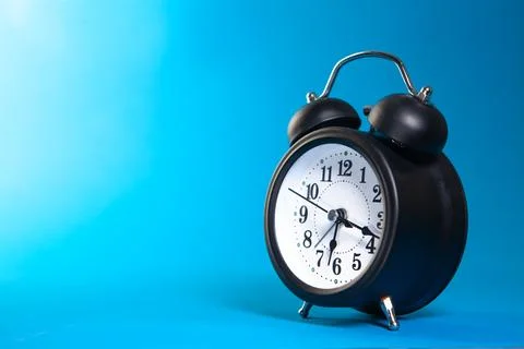 Blue clock on a black background Stock Photos