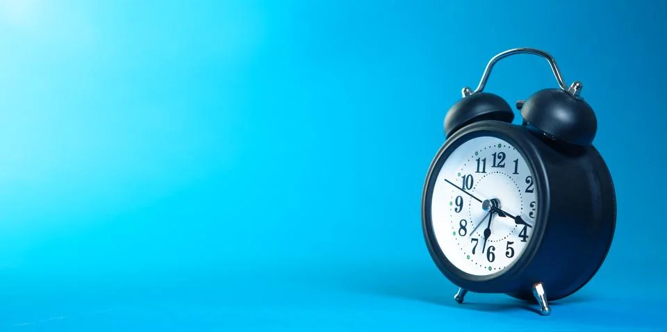 Blue clock on a black background Stock Photos