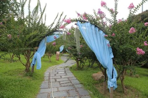 The blue cloth material is hung on the trees in front of the garden, with p.. Foto stock