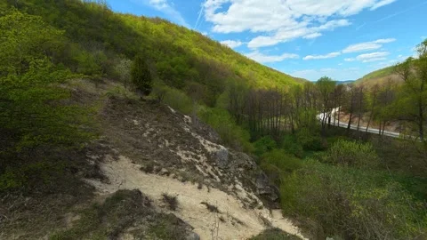 Blue clouds drift above rolling forested terrain. Balkan, Eastern Europe, POV Stock Footage 333588056