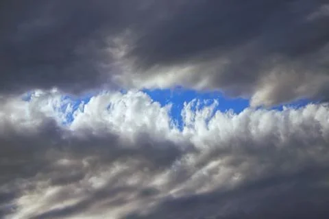 Blue clouds in the middle of black clouds Stock Photos
