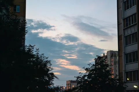 Blue clouds in the morning sky between high-rise buildings Foto stock