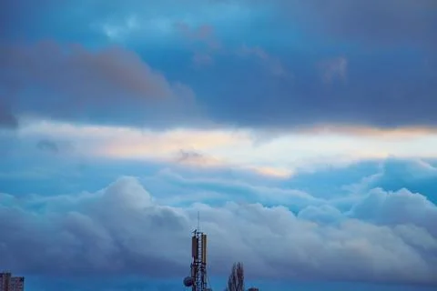 Blue clouds in the sky and a light streak on the horizon above the communicat Foto stock