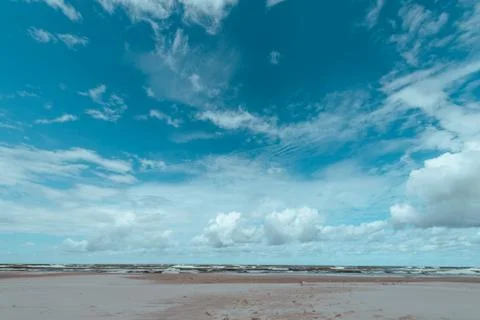 Blue cloudy sky over empty sandy beach on summer day Foto stock