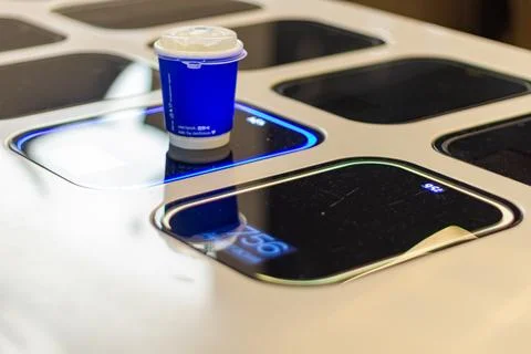 Blue coffee cup on automatic vending machine with digital display screen Stock Photos