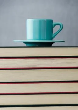 Blue coffee cup on stack of books Stock Photos