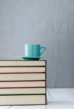 Blue coffee cup on stack of books Stock Photos