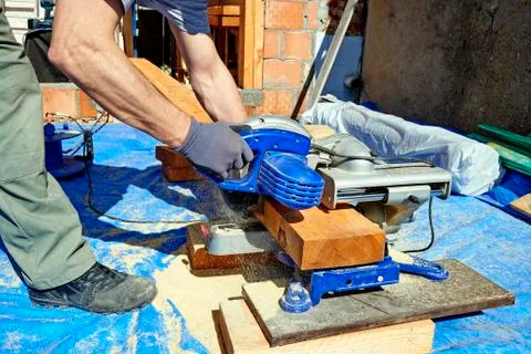 Blue collar carpenter using electric saw Stock Photos