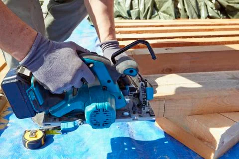 Blue collar carpenter using electric saw Stock Photos