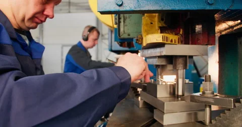 Blue collar punch press operators working at metal stamping machines Stock Footage 340066279