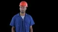 Blue collar worker adjusts safety orange safety helmet HD Footage