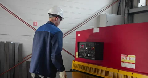 Blue-collar worker control sheet metal cutting process on industrial guillotine Stock Footage 326219551
