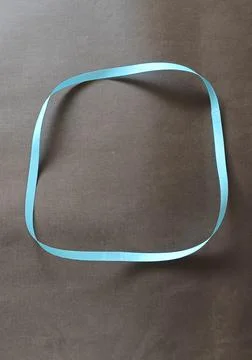 Blue color different shape mobius strip or band isolated on brown background Stock Photos