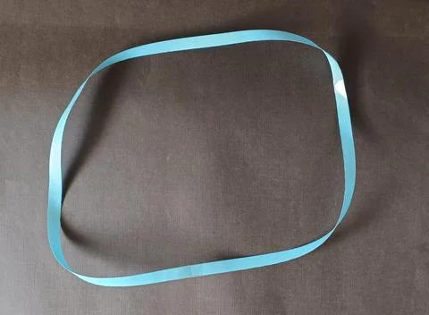 Blue color different shape mobius strip or band isolated on brown background 스톡 사진
