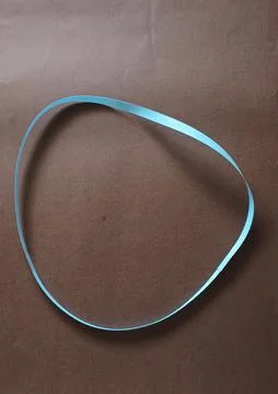 Blue color different shape mobius strip or band isolated on brown background Stock Photos