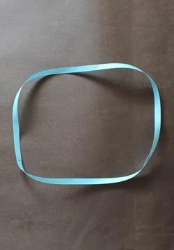 Blue color different shape mobius strip or band isolated on brown background Foto stock