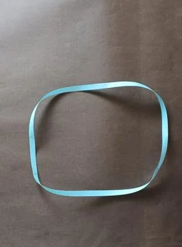 Blue color different shape mobius strip or band isolated on brown background Stockfoto's