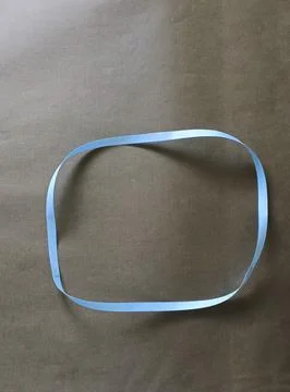 Blue color different shape mobius strip or band isolated on brown background 스톡 사진