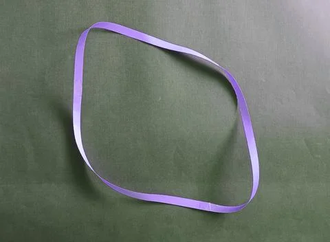 Blue color different shape mobius strip or band isolated on brown background Stockfoto's