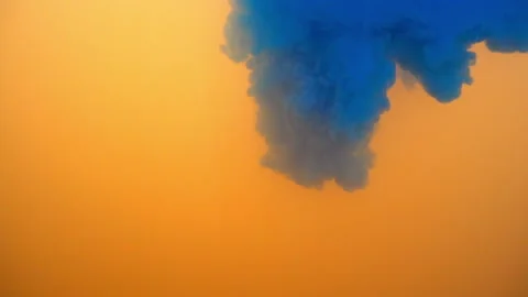 Blue color falling into orange background in slow motion. Stock Footage 104775498