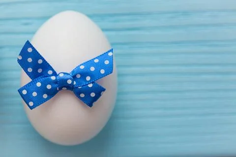 Blue colored Easter egg with white spotted is on the wooden background. Stock Photos