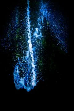 Blue colored water exploding down through the air Stock Photos