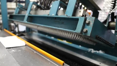 Blue comb-toothed machine pulling and straightening rows of white cotton wick Stock Footage 343875926