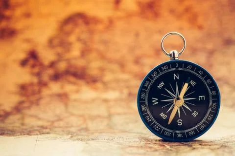 The blue compass is placed on the world map. Stock Photos