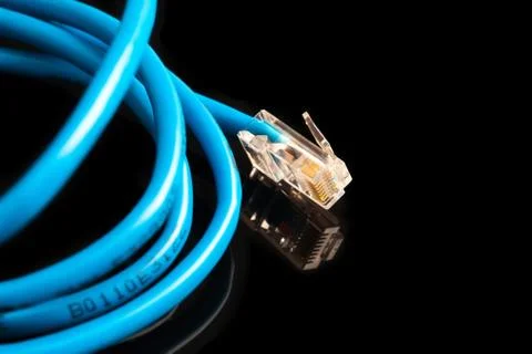 Blue computer ethernet cable isolated on black background, close-up Foto stock