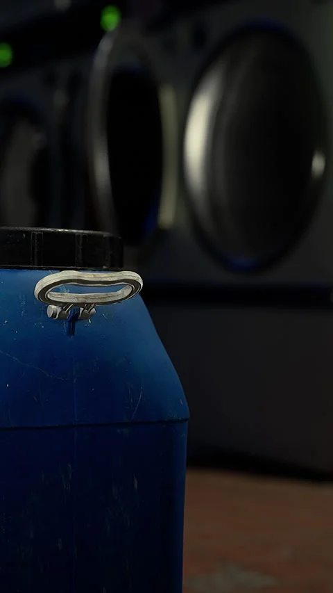 Blue container in a laundry area with washing machines in background Stock Footage 340635816
