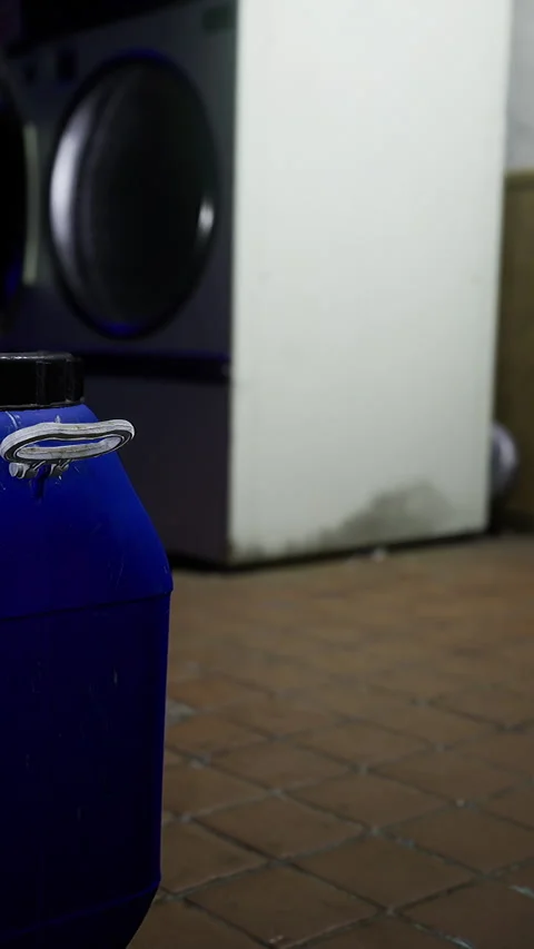 Blue container near washing machine in indoor laundry space Stock Footage 342448765