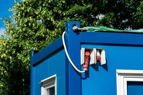 Blue container with power outlets in bright sunlight Stock Photos