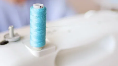 Blue cotton spool thread unwinds on a sewing machine. Stock Footage 224088402