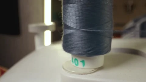 Blue cotton spool thread unwinds on a sewing machine. Spinning roll of threads Stock Footage 269812389