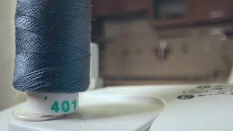Blue cotton spool thread unwinds on a sewing machine. Spinning roll of threads Stock Footage 269813045
